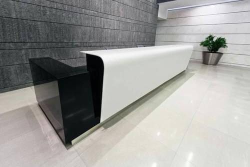 Mẫu quầy lễ tân tại một không gian lớn được thiết kế bằng đá Himacs màu trắng kết hợp màu đen tạo nên sự tương phản giữa 2 màu vẫn làm nổi bật sự sang trọng của đá ốp Himacs.
